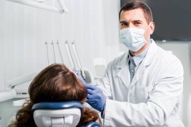 dişçi maskeli kadın lateks eldiven ile çalışma