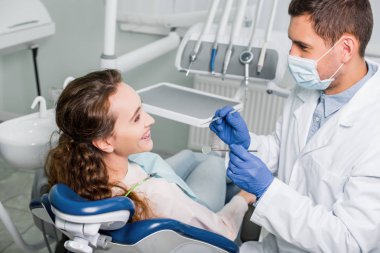 dişçi diş Kliniği içinde gülümseyen kadın yakın duran maskesi ve lateks eldiven