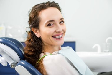 mutlu kadın diş Kliniği olarak muayene sırasında gülümseyen parantez içinde
