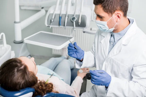 Dentista Grave Luvas Látex Máscara Segurando Equipamentos Odontológicos Perto Paciente — Fotografia de Stock