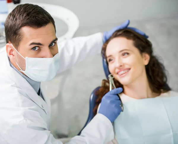 Επιλεκτική Εστίαση Του Οδοντιάτρου Κρατώντας Οδοντιατρικό Όργανο Κοντά Χαμογελώντας Ασθενή — Φωτογραφία Αρχείου