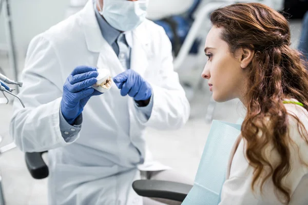 Beskåret Visning Tandlæge Latexhandsker Med Tandmodel Nær Kvindelig Patient - Stock-foto