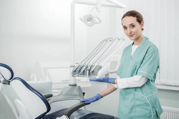 Mooie Tandarts Glimlachen Terwijl Het Gebaren Tandheelkundige Kliniek — Stockfoto