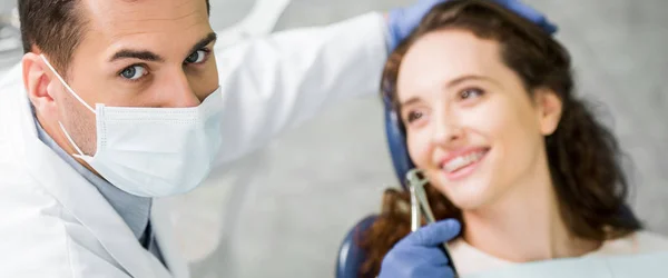 Foco Seletivo Dentista Máscara Segurando Instrumento Dentário Perto Paciente Sorridente — Fotografia de Stock