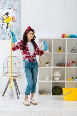 Ekose gömlek ve mavi kauçuk eldiven paspas ile ayakta çok Afrikalı-Amerikalı kadın