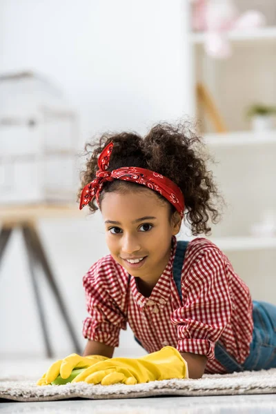 Lächelndes Afrikanisch Amerikanisches Kind Gelben Gummihandschuhen Auf Weißem Teppich Liegend — Stockfoto
