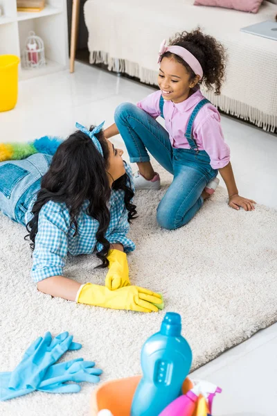 Afrikanerin Gelben Gummihandschuhen Auf Teppich Liegend Während Tochter Der Nähe — Stockfoto