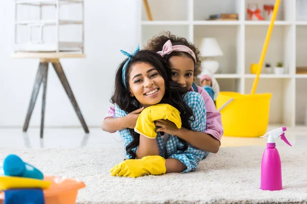 Adorable African American Child Embracing Mother While Lying Carpet — Stock Photo, Image