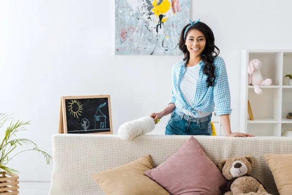 Attractive African American Woman Standing Sofa Holding White Duster — Stock Photo, Image