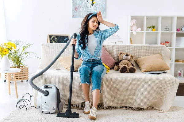 Lelah African American Wanita Duduk Sofa Sambil Memegang Tongkat Vacuum — Stok Foto