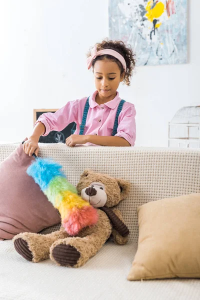 可爱的非洲裔美国儿童清洁泰迪熊与五颜六色的除尘器 — 图库照片