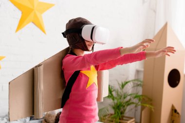 Vr kulaklık daimi eller yukarı yatak ile gülümseyen çocuk