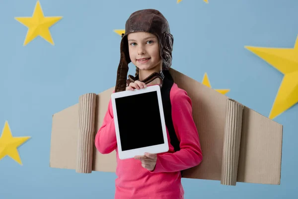 微笑的孩子在飞行头盔拿着数字平板电脑与空白屏幕在蓝色星空背景 — 图库照片