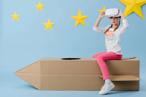 Niño Sentado Cohete Cartón Quitándose Los Auriculares Sobre Fondo Azul — Foto de Stock