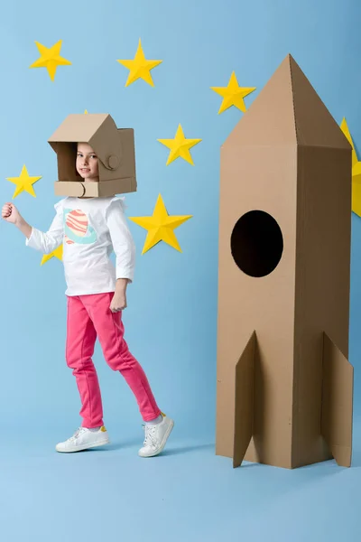 Funny Kid Helmet Standing Cardboard Rocket Blue Background Stars — Stock Photo, Image