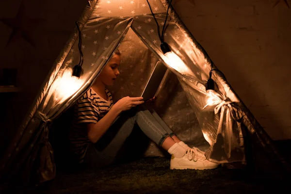 Criança Usando Laptop Enquanto Sentado Wigwam Quarto Escuro — Fotografia de Stock