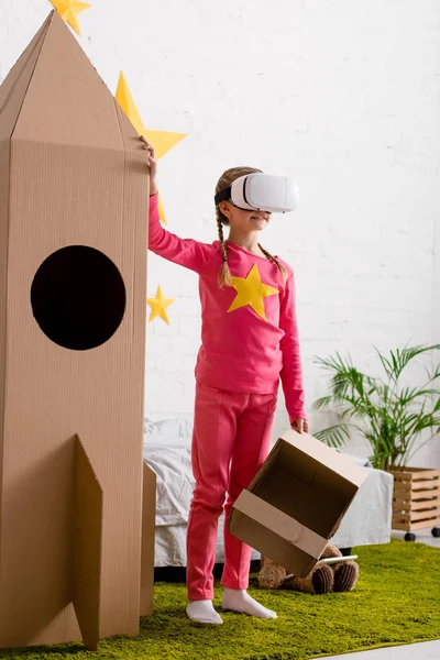 Kid Headset Holding Cardboard Helmet Touching Big Rocket Bedroom — Stock Photo, Image