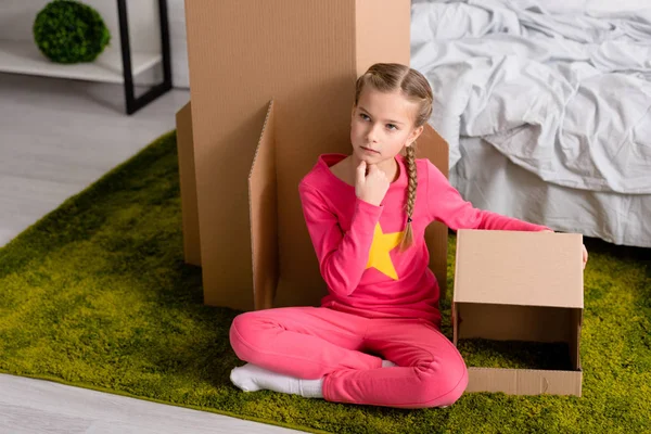 Verträumtes Kind Pinkfarbener Kleidung Sitzt Auf Teppich Mit Papphelm — Stockfoto