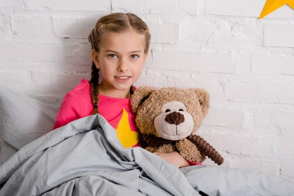 Curious Kid Braids Holding Teddy Bear Bed — Stock Photo, Image