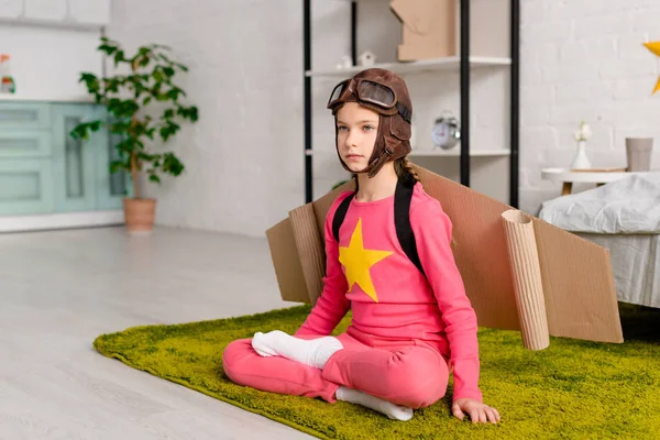 Serious Child Cardboard Wings Sitting Lotus Pose Carpet — Stock Photo, Image
