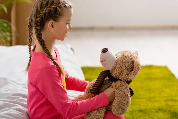 Seitenansicht Eines Kindes Mit Zöpfen Beim Anblick Eines Teddybären — Stockfoto