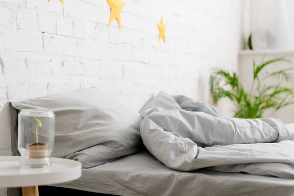 Cozy light bedroom with bed and green plants