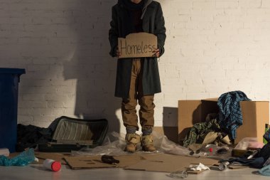 cropped view of houseless man holding piece of cardboard with 