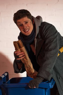 mutlu evsiz adam ekmek baget duran Çöp konteyner tarafından holding