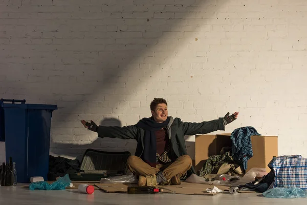 Smiling Homeless Man Sitting Cardboard Surrounded Rubbish Spreading Arms — Stock Photo, Image