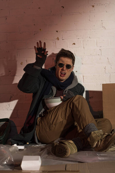 angry screaming homeless man throwing popcorn from bowl
