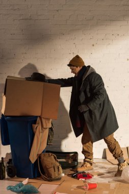 karton kutu çöp ile Çöp konteyner içine iterek evsiz begar adam
