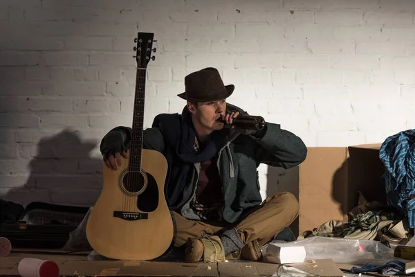 Hombre Sin Hogar Sosteniendo Guitarra Beber Botella Alcohol Mientras Está — Foto de Stock