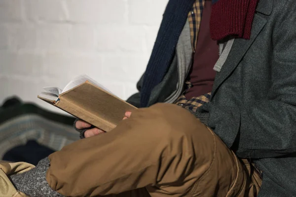 Recortado Vista Hombre Sin Hogar Lectura Libro Mientras Está Sentado — Foto de Stock