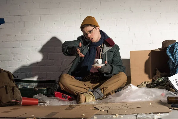 Homeless Man Holding Coffee Cup Using Vintage Phone While Sitting — Stock Photo, Image