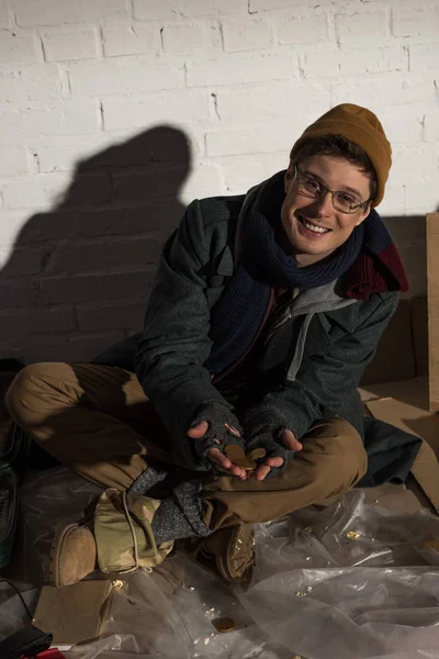 Smiling Homeless Man Sitting Rubbish Dump Holding Coins Open Hands — Stock Photo, Image