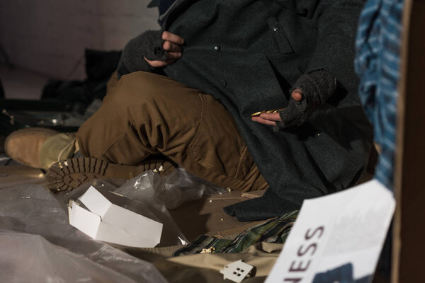 partial view of homeless beggar man getting out coins from pocket 