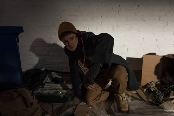 ゴミ捨て場に膝の上に立って酔って怒っているホームレスの男性 — ストック写真