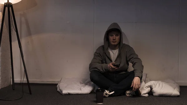 Man Using Smartphone While Sitting Mattress Arranged Floor Dark Room — Stock Photo, Image