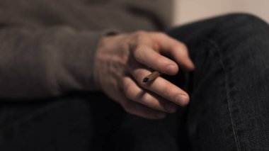 selective focus of male hand with rolled marijuana cigarette clipart