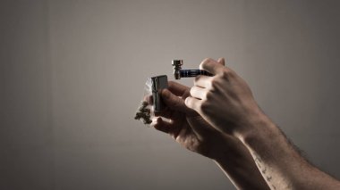 erkek dövmeli sigara boru ve hafif gri arka plan üzerinde tutarak kısmi görünümü