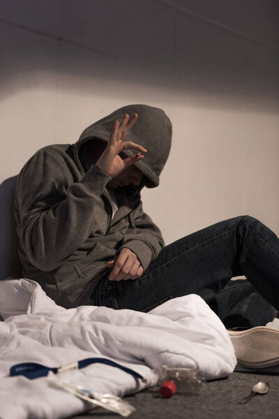 addict man under narcotic influence holding marijuana rolled cigarette