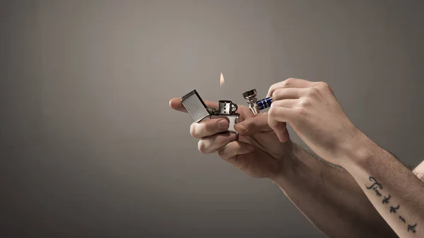 Обрезанный Вид Мужчины Татуировкой Металлической Дымящейся Трубкой Зажигалкой Сером Фоне — стоковое фото