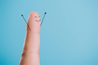 cropped view of one finger with happy face isolated on blue clipart