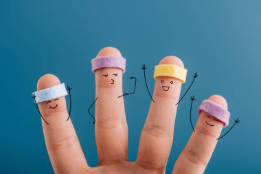 cropped view of cheerful sporty fingers in headbands isolated on blue clipart