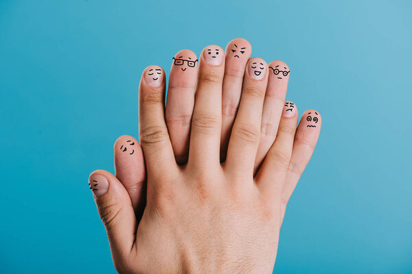 cropped view of fingers with different emotions isolated on blue