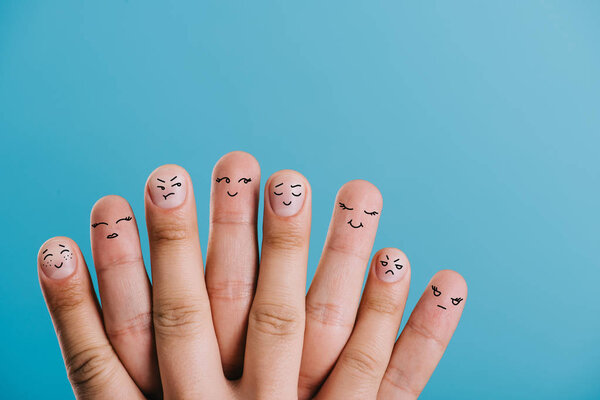 cropped view of human fingers with different emotions isolated on blue