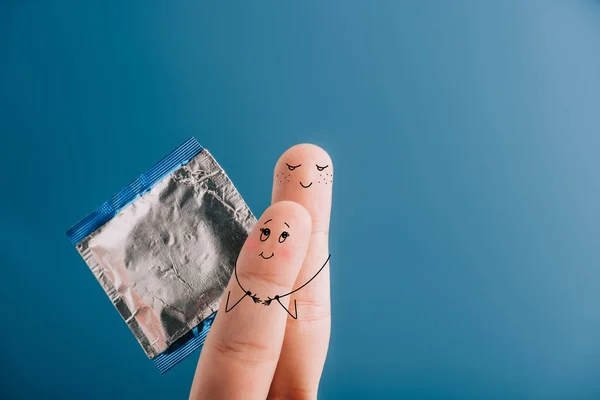 Обрезанный Вид Счастливой Пары Пальцев Обнимающих Держащих Презерватив Изолированный Синий — стоковое фото