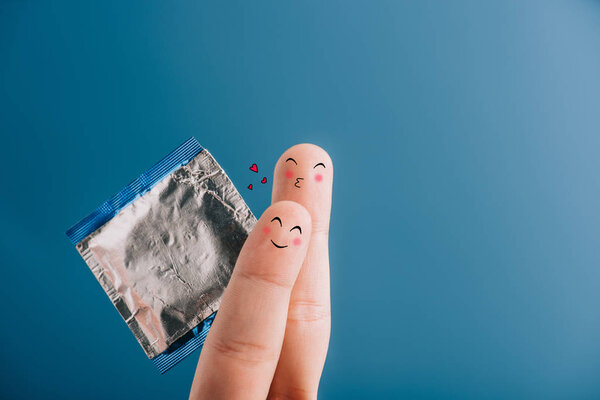 cropped view of happy couple of fingers with condom isolated on blue