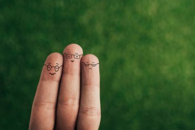 cropped view of happy fingers in eyeglasses on green clipart