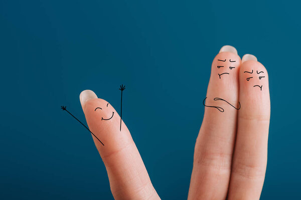 cropped view of fingers in bad mood looking at one happy finger isolated on blue